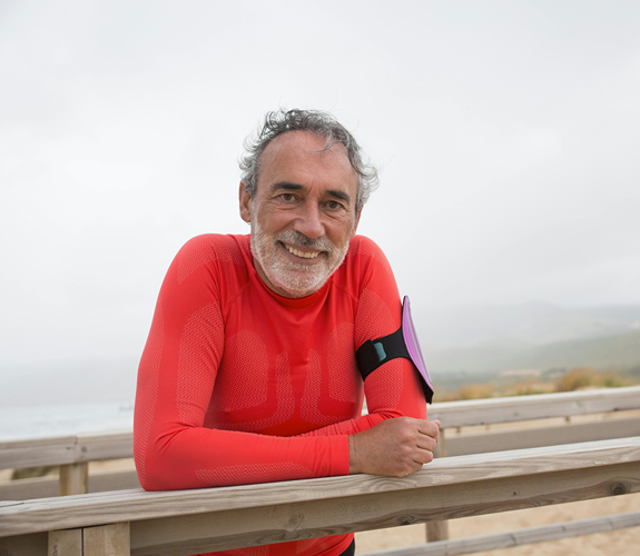 person in red top leaning on wodden fence